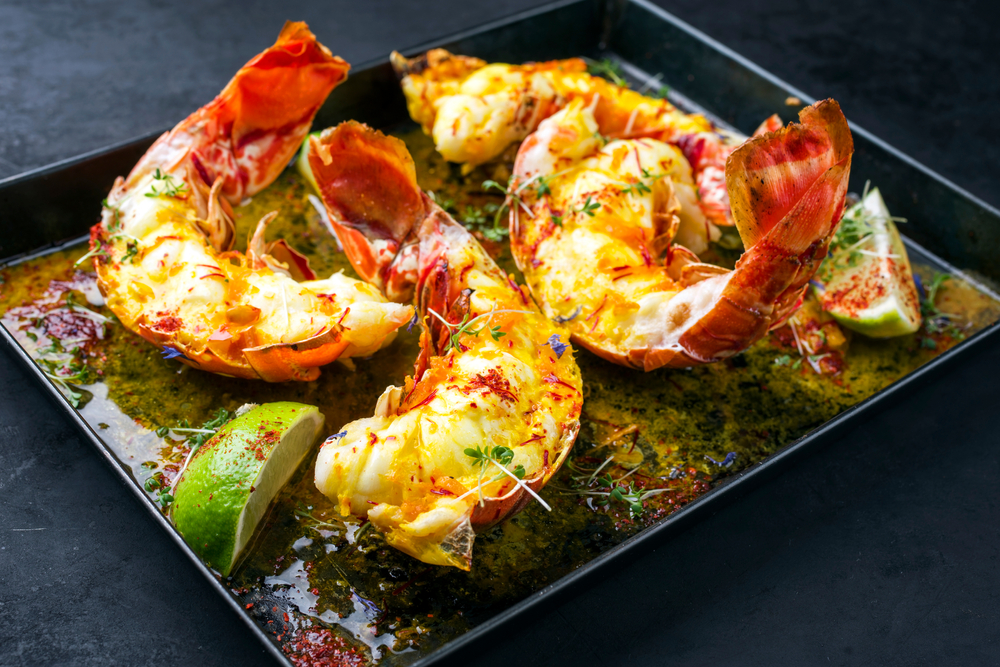 cooke lobster tail on a plate with butter and a lot of seasoning