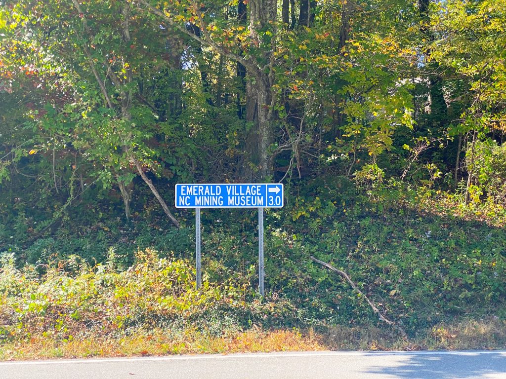 blue road sign directing drivers to the North Carolina Mining museum one of the things to do near Little Switzerland NC