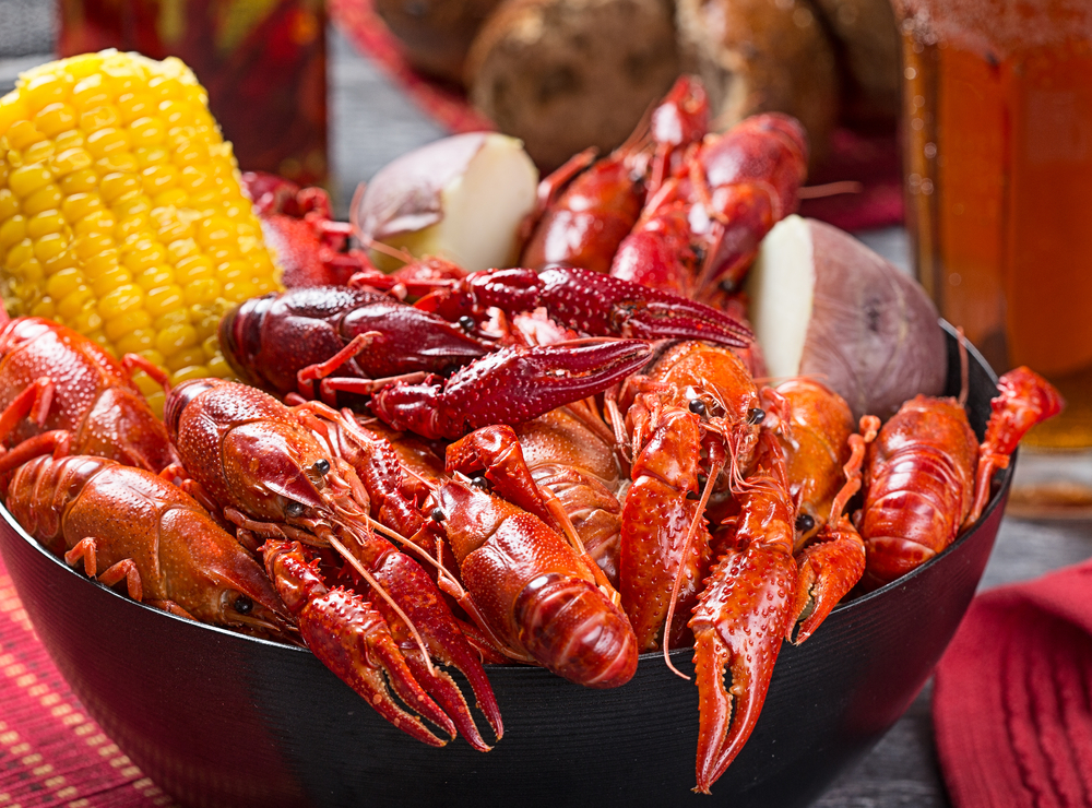 A bowl of boiled crawfish with corn on the cob and potatoes.