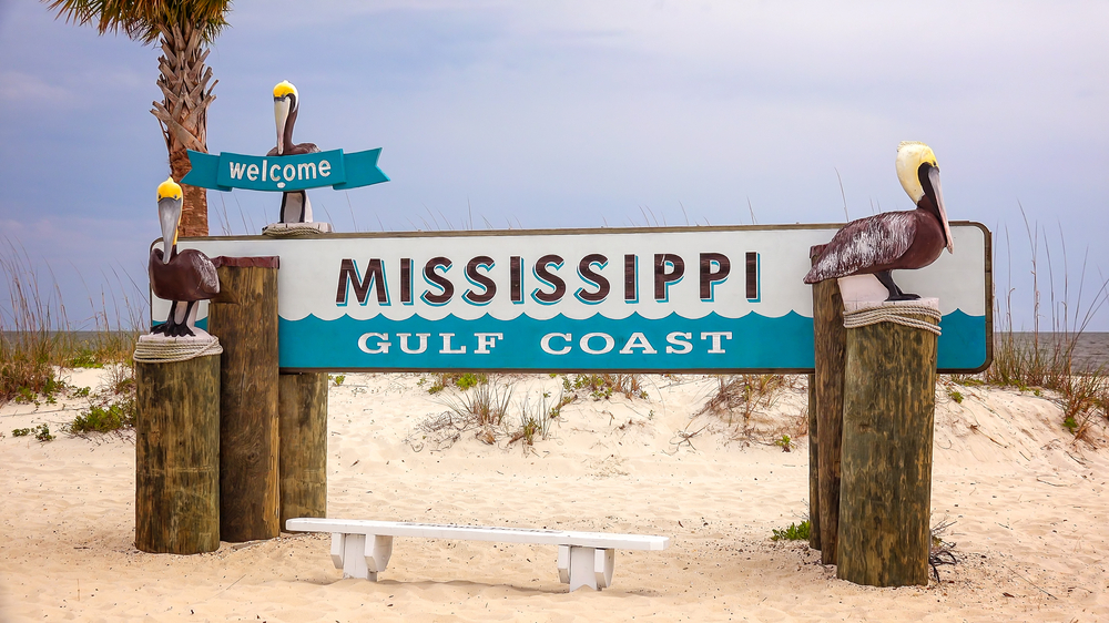 Sign for the Mississippi Gulf Coast with wooden, carved pelicans in Gulfport.