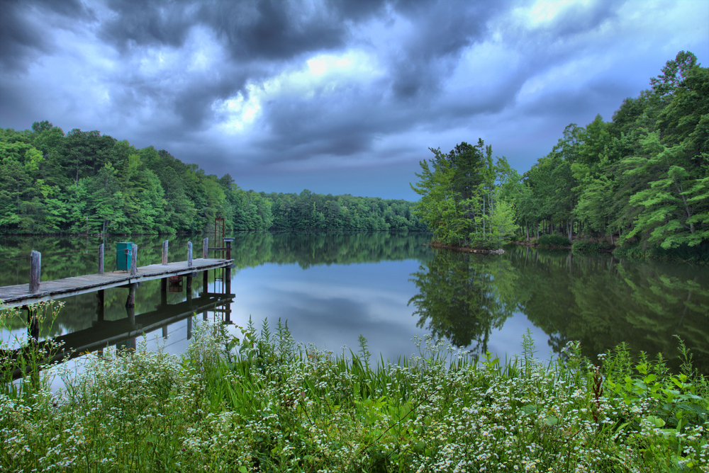 Dock jutting into a lake on a stormy afternoon at Madison County Nature Trail at Green Mountain, one of the best things to do in Huntsville.
