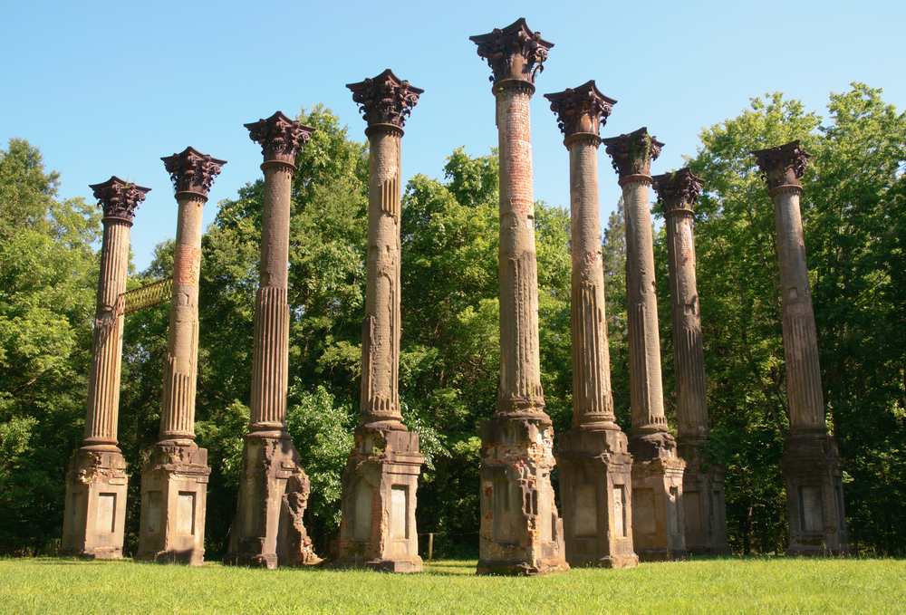 The Windsor Ruins look eerie standing alone in a field with trees in the background.