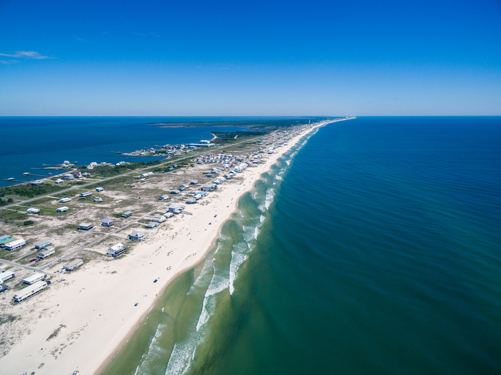 An aerial view of Gulf Shores Alabama. You can see white sand beaches, houses, and the Gulf of Mexico. 