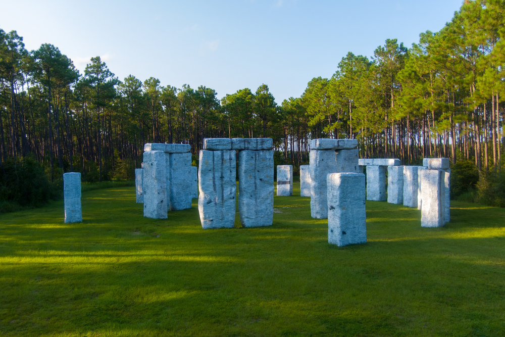 A fiberglass replica of Stonehenge in a pine tree forest. 