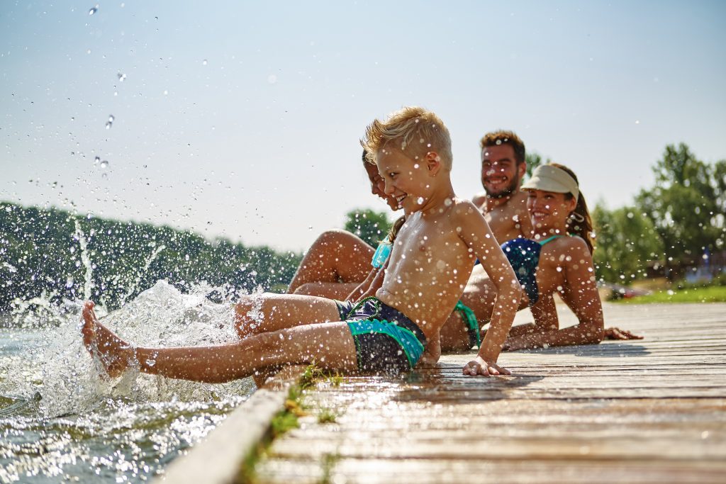 happy family on a dock at lake splashing