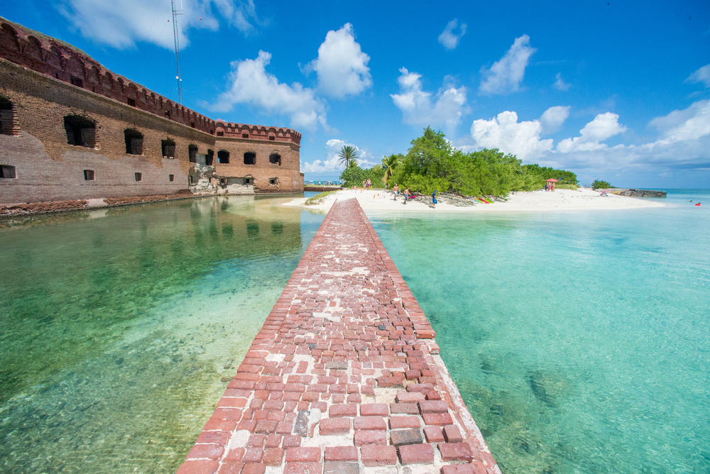 Looking down an old brick cobblestone path that is in the middle of the ocean. It leads to a small island and on one side you can see an old historic fort. One of the best islands in the south. 