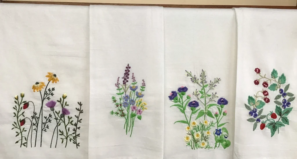 white tea towels embroidered with colorful floral patterns; a great option for southern gifts