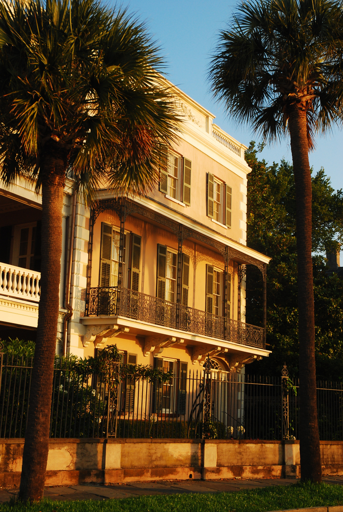 Side view of the exterior of the Edmondston-Alston House during golden hour with palm trees.