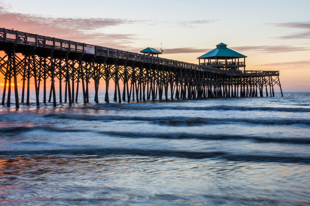 The Folly Beach Pier jutting into the water at sunset.