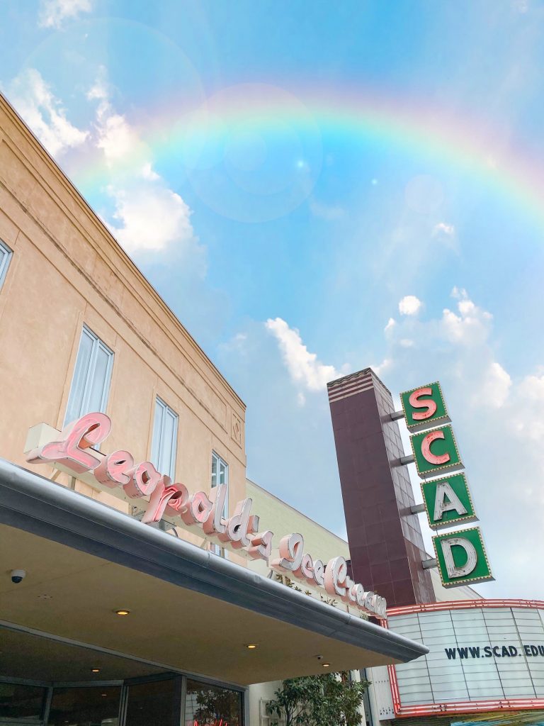 A rainbow arching over the facade of Leopold's Ice Cream.