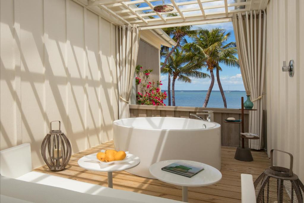 One of th rooms overlooking the ocean and palm trees with large soaking tub at this romantic private island all inclusive resort in the south