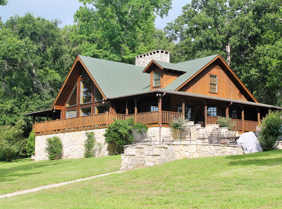 This modern ranch is the ultimate all inclusive resort for those who love the outdoors the log cabin with stone wall and trees