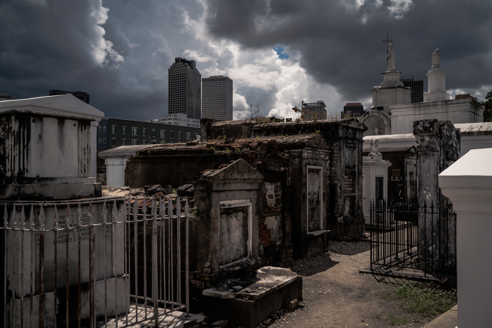 An old cemetery in New Orleans with large dark clouds looming over it. 