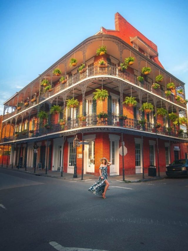 woman standing in front of a balcony on the french quarter in new orleans