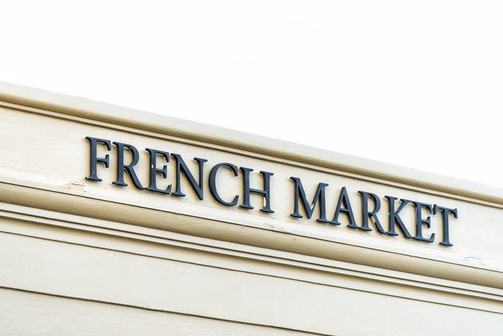 The front sign of the French Market, which is white with black lettering. Its one of the best places to visit in New Orleans. 