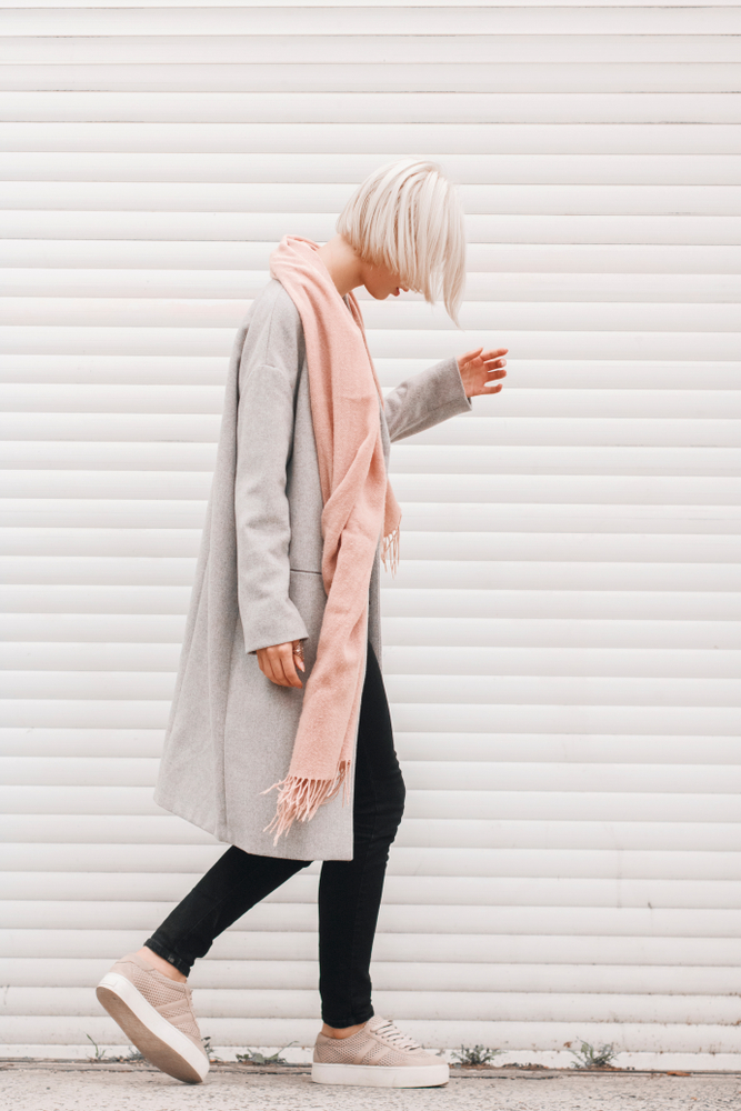 A woman walks in fleece lined leggings and a pink scarf, a perfect outfit with layers for winter in the south.