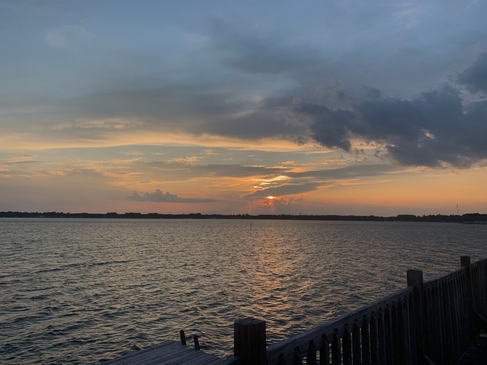 dock overlooking expansive lake with trees far in the background