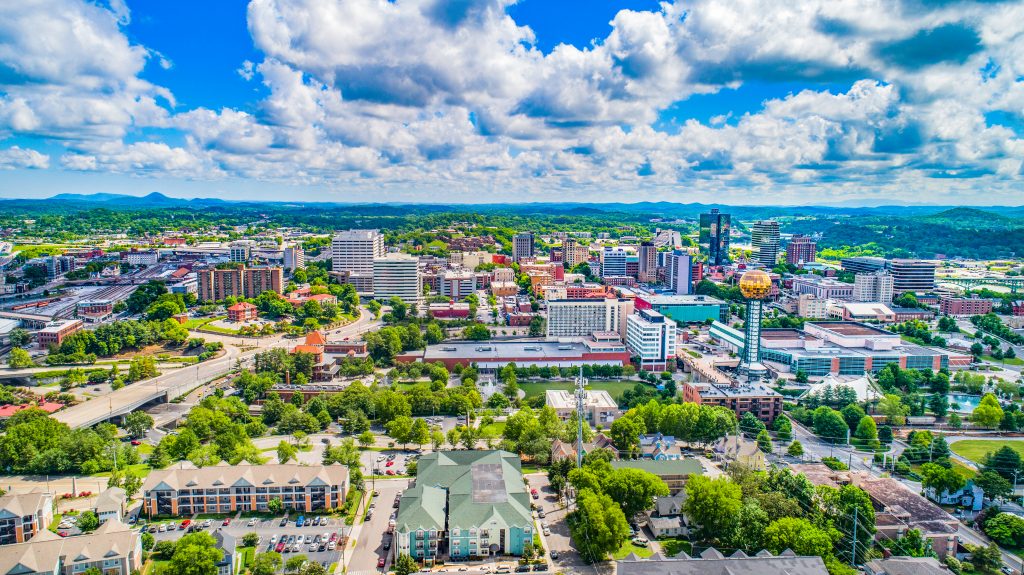 Aerial view of Knoxville featuring the skyline and mounatns beyond. 