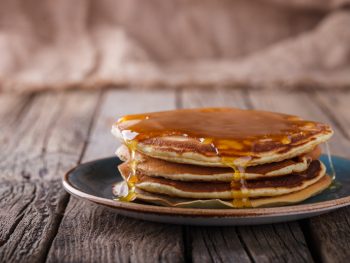 A closeup of a small stack of pancakes with syrup running down the sides, one of the most popular foods for breakfast in Gatlinburg.