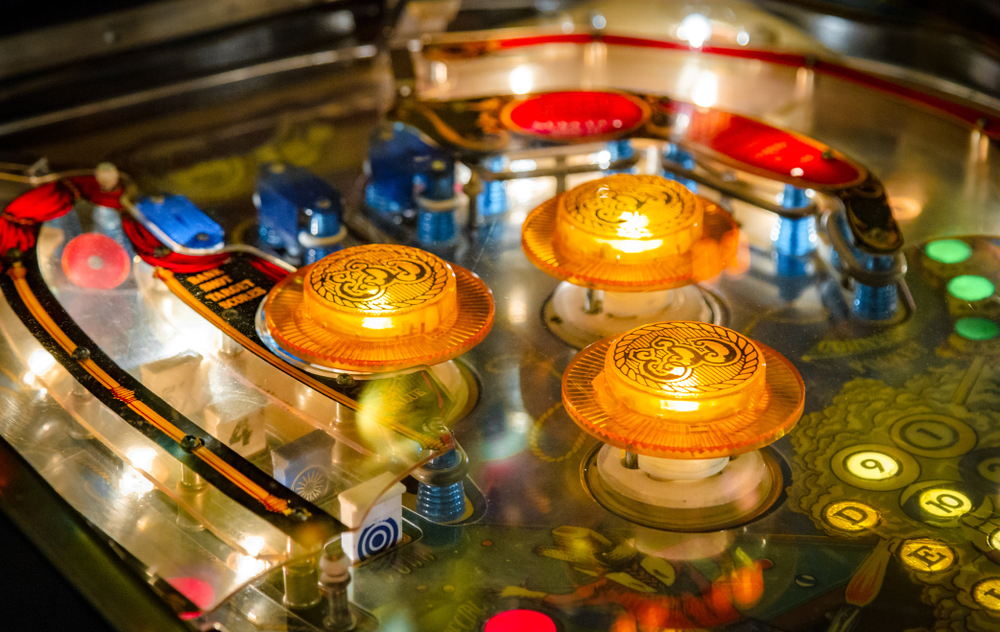 Close-up photo of a brightly colored, lit-up pinball machine.