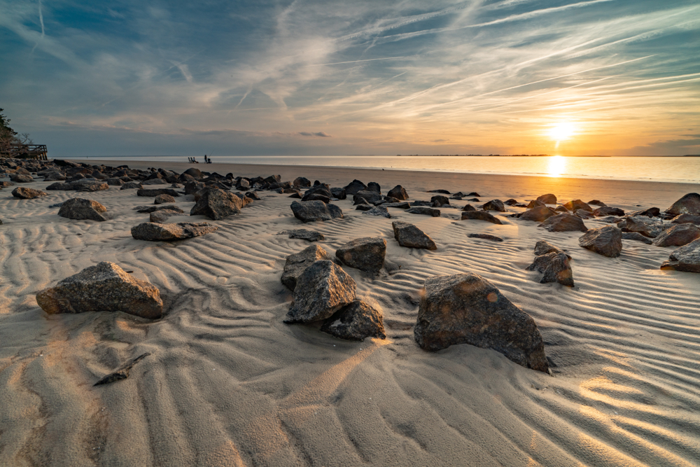 A beach with rocks on at sunset. 