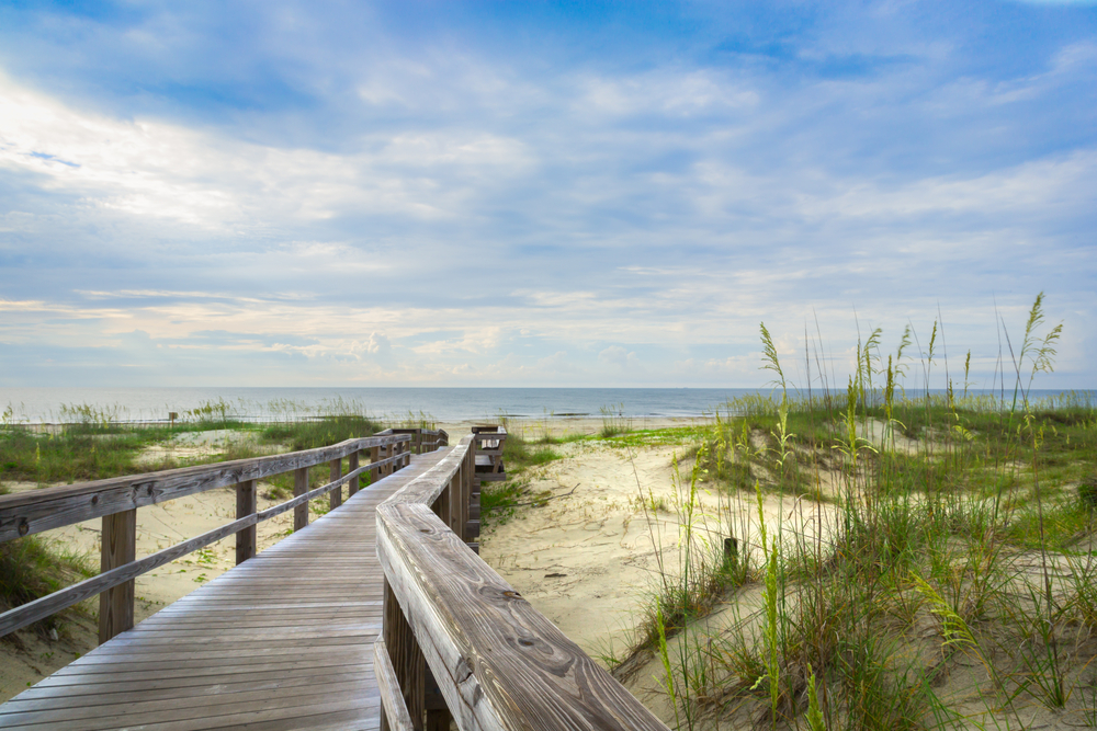 A broadwalk across sand dunes in an article about beaches in Savannah   