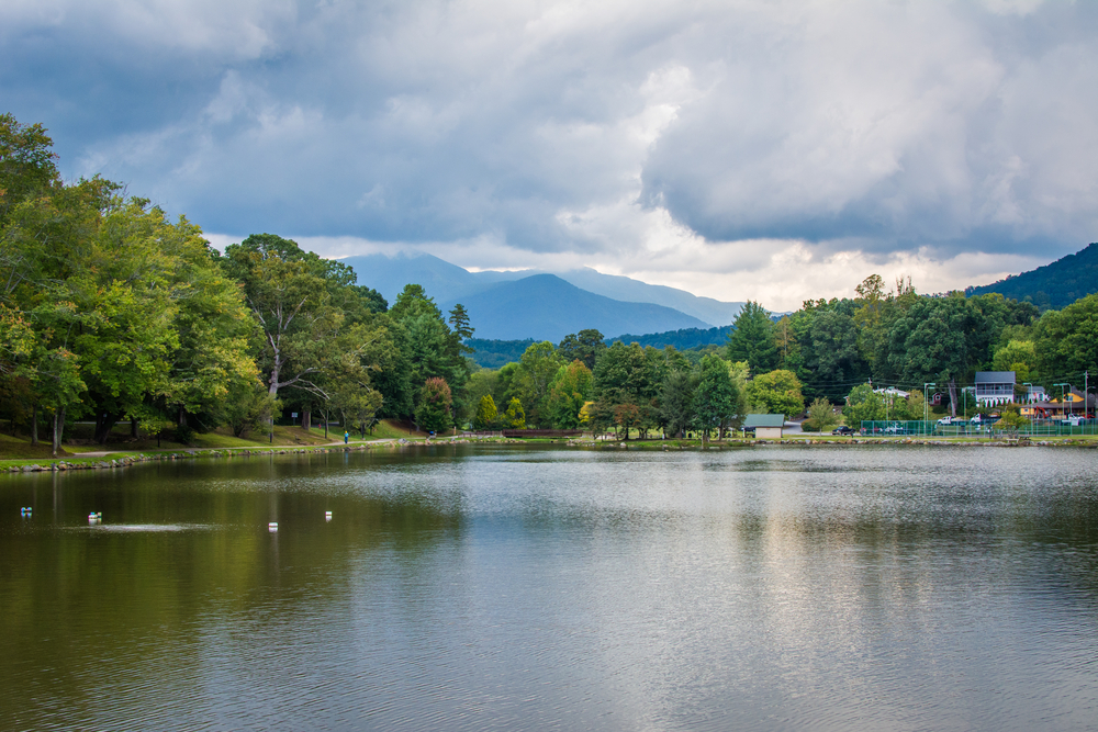 A large lake where you can see a town on the shore. Behind it there are large mountains. It's one of the best day trips from Asheville. 