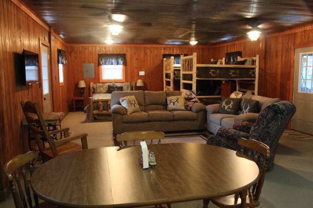 small cabin interior with bunk beds, table, and other furniture. 