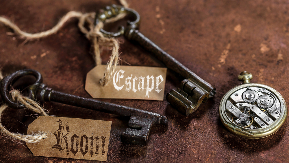 Two keys labeled an escape room and a clock lie on a table, reminding us that for a date night in Atlanta this is a fun and timed game.
