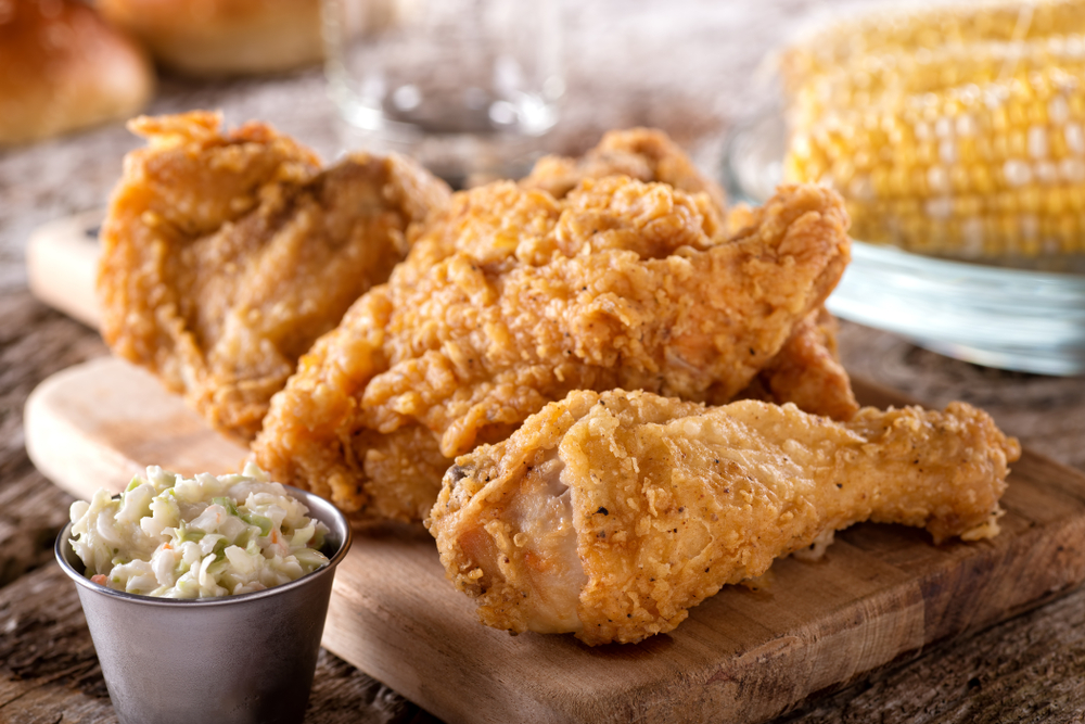 southern freid chicken on a board with a side of sweetcorn and coleslaw. In an article about restuarants in Pigeon Forge.