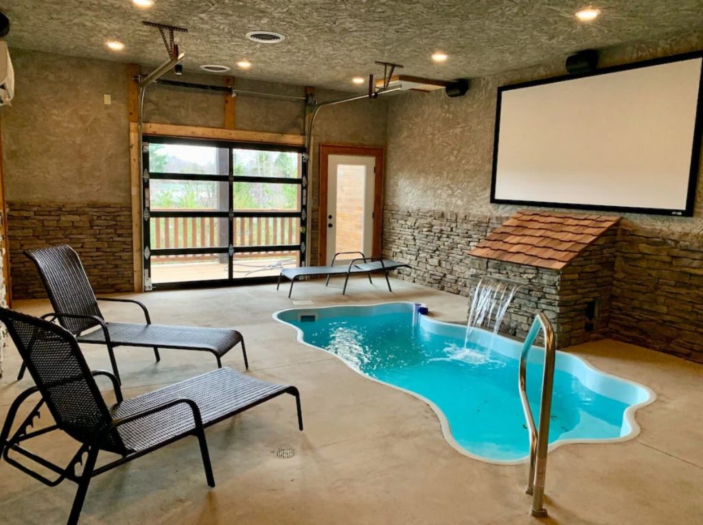 A small indoor pool in a pool room attached to one of the best cabins in Gatlinburg. The pool has a small waterfall. There are also lounge chairs. It's one of the best cabins in Gatlinburg 