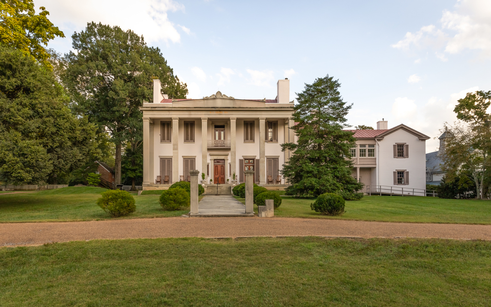 historic building with trees and grass in front and on sides