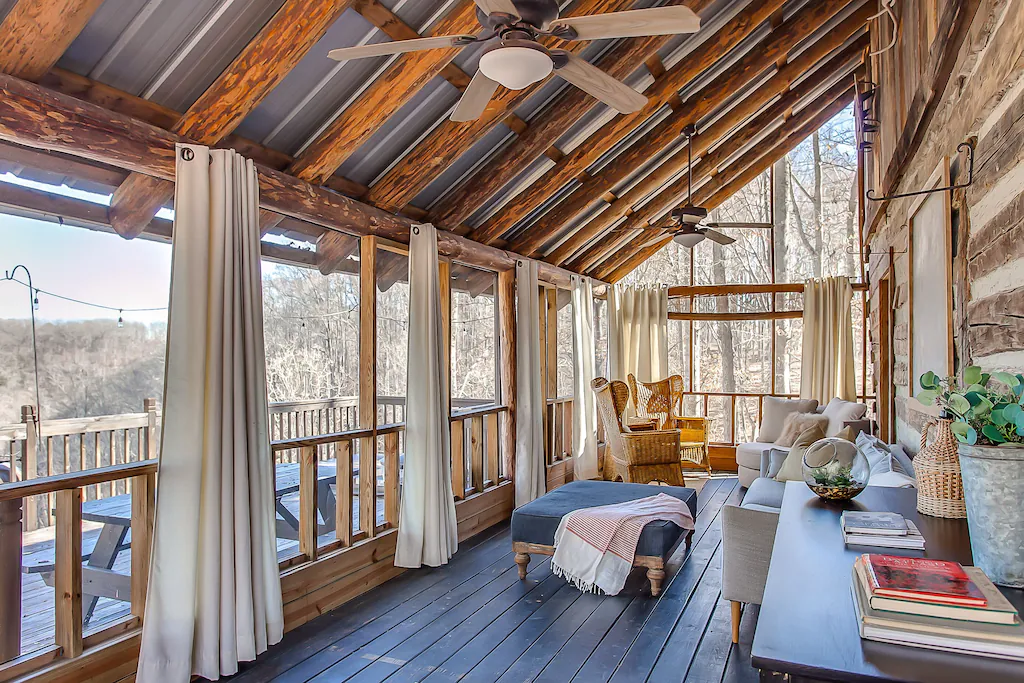 An increadible deck area of one the the treehouses in Tennessee. This screened in porch has tables and chairs and leads out to a deck with great views. 