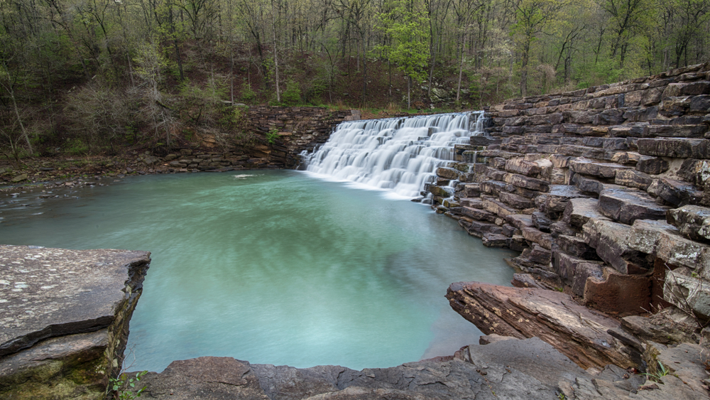 Rocks and a waterfall with a small pond showcasing the nature of Devils Den. One of many oasis's found in state parks in Arkansas. 
