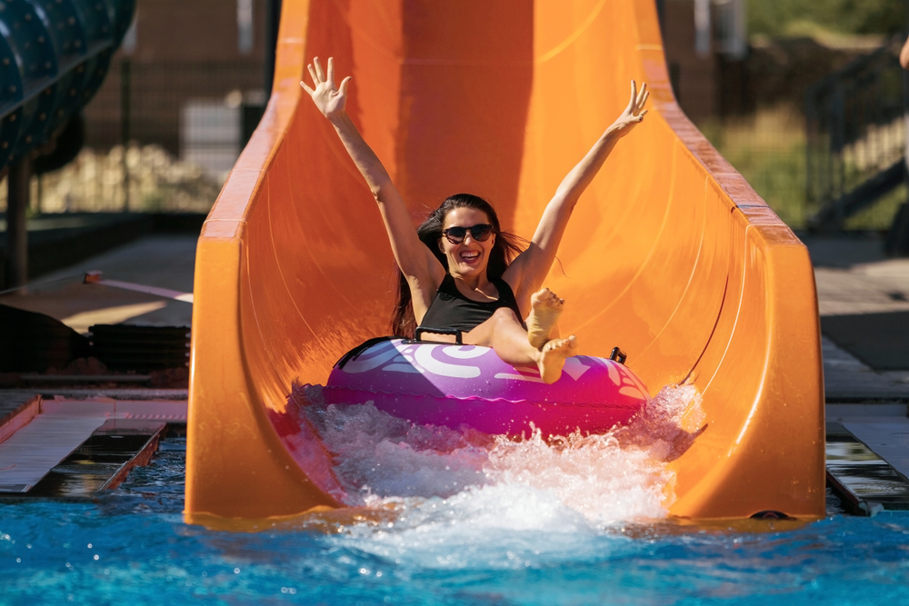 Girl splashing down at the end of a water slide at one of the amusement parks in Georgia. 