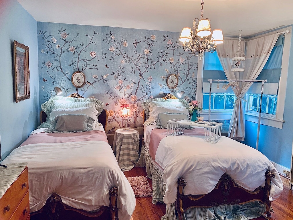View of a double twin bed room with amazing blue vintage wallpaper and bedding. 