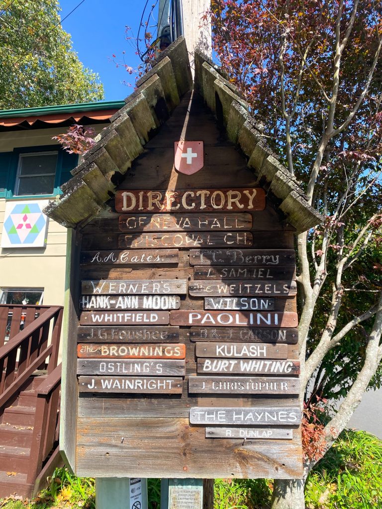 wooden sign with store names on it