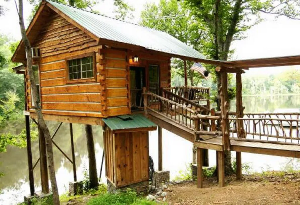 Photo of the exterior of Tree Cabin, overlooking the river. 