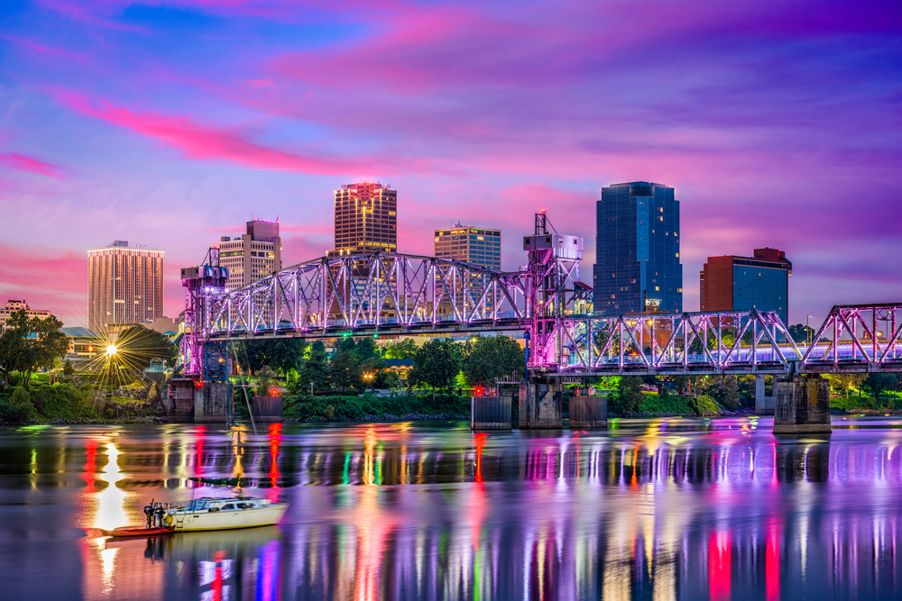 the vibrant city at sunset with downtown in the background and water in foreground with a boat