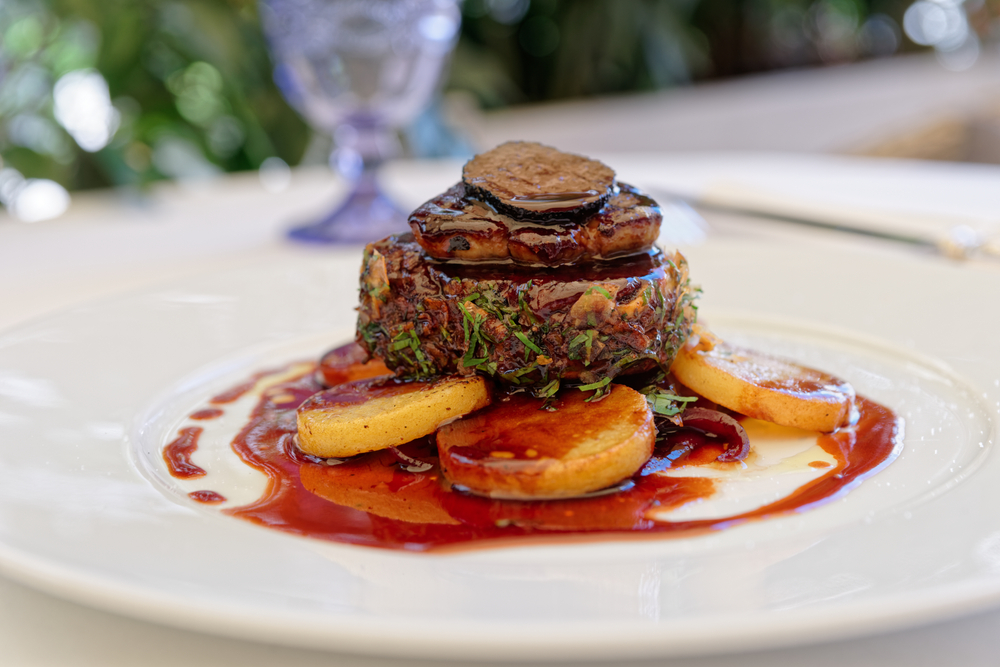 a steak topped with mushroom served over potatoes and a sauce at one of ht restaurants in little rock AR