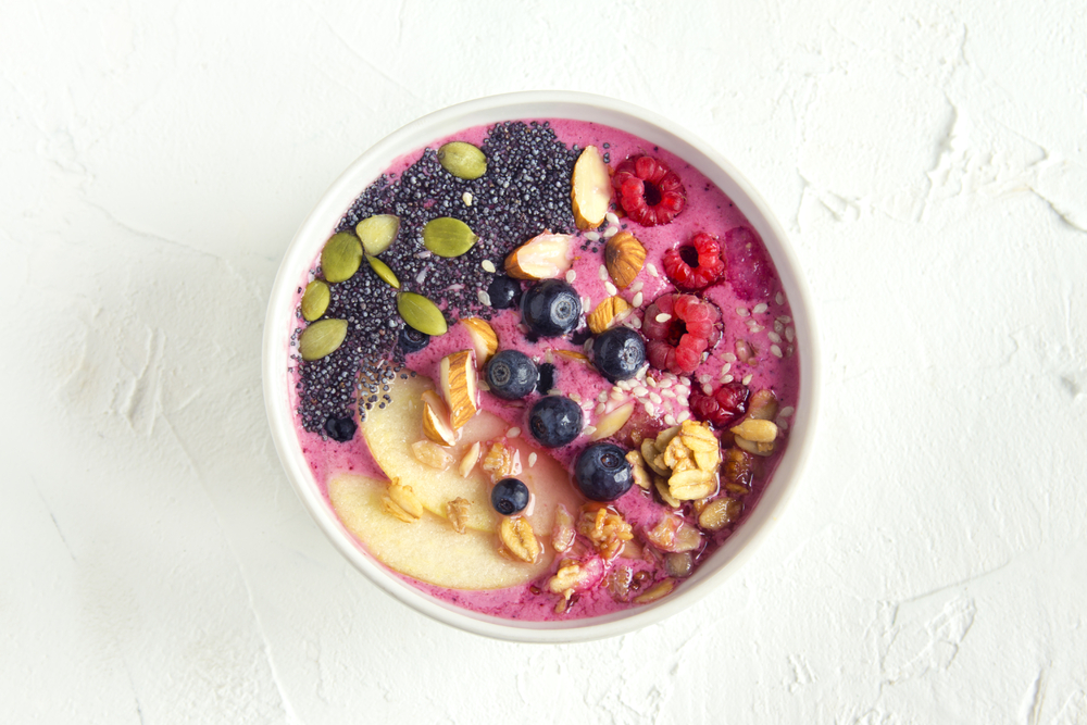 A pink smoothie breakfast bowl full of nuts and fruits, like one you can order at Beech for a healthy breakfast in Charleston.