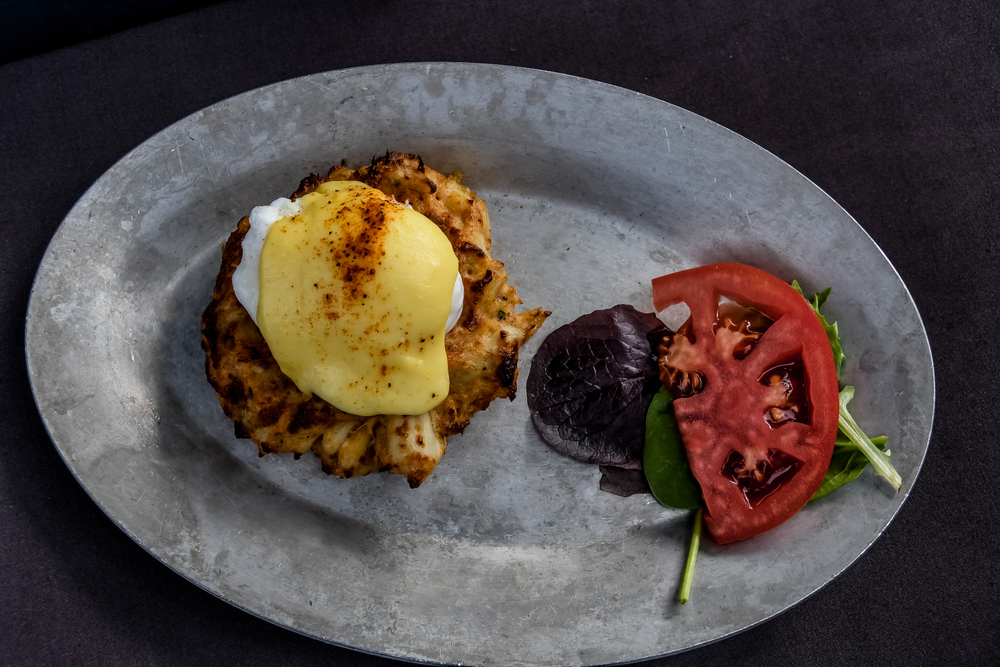 A poached egg on a crab cake with veggie garnish, like that served at Toast All Day for breakfast in Charleston.