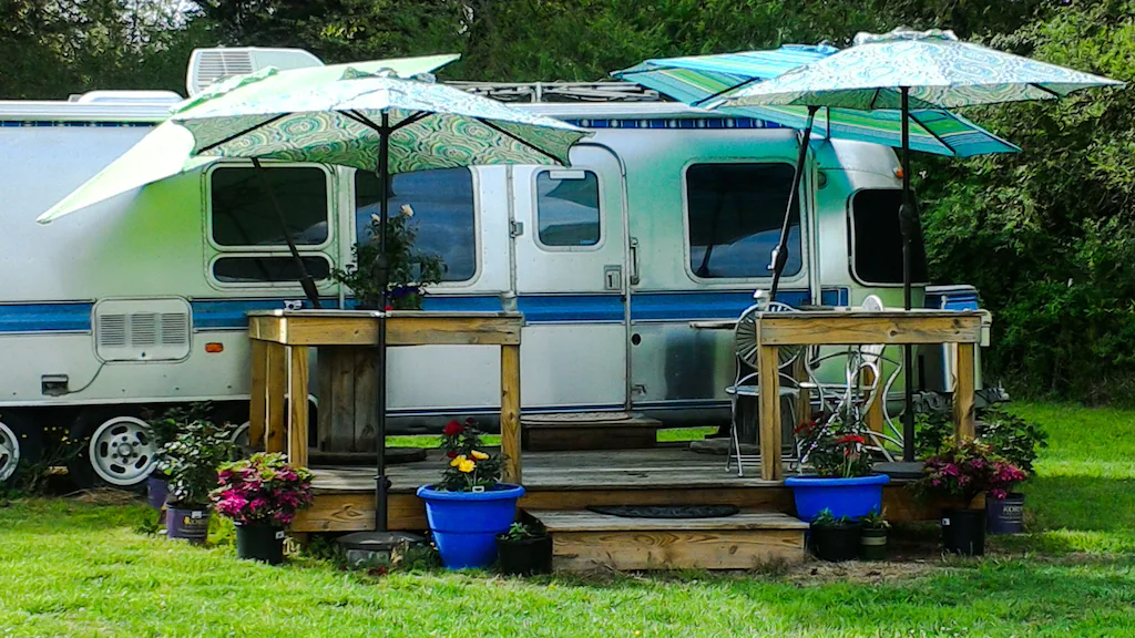 an airstream rv with umbrellas displayed at a great glamping site in tennessee