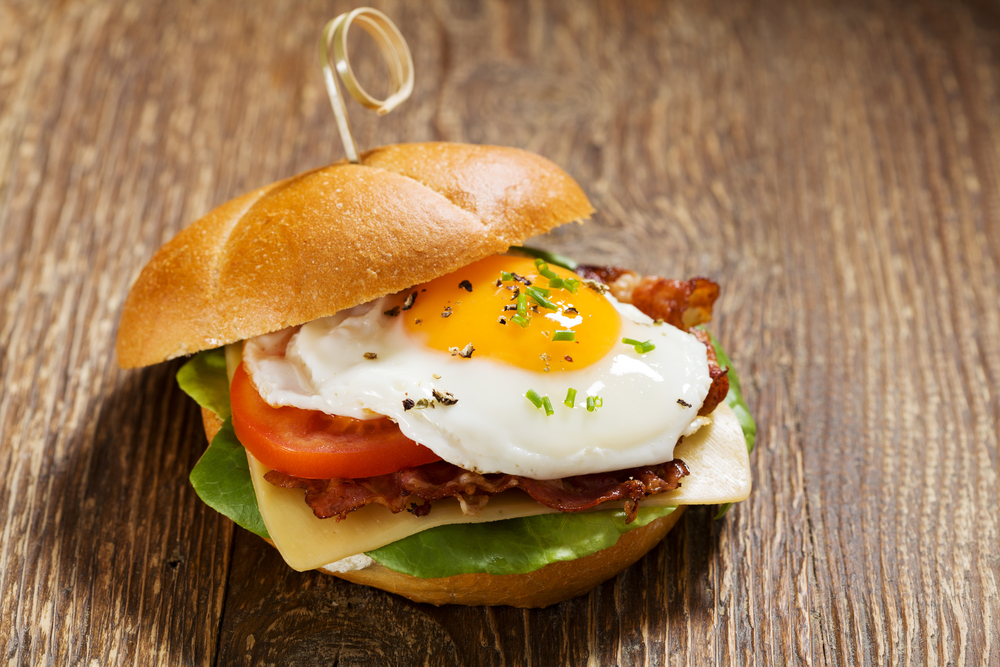 photo of a bacon and egg breakfast sandwich on a wood table at one of the best restaurants in Memphis