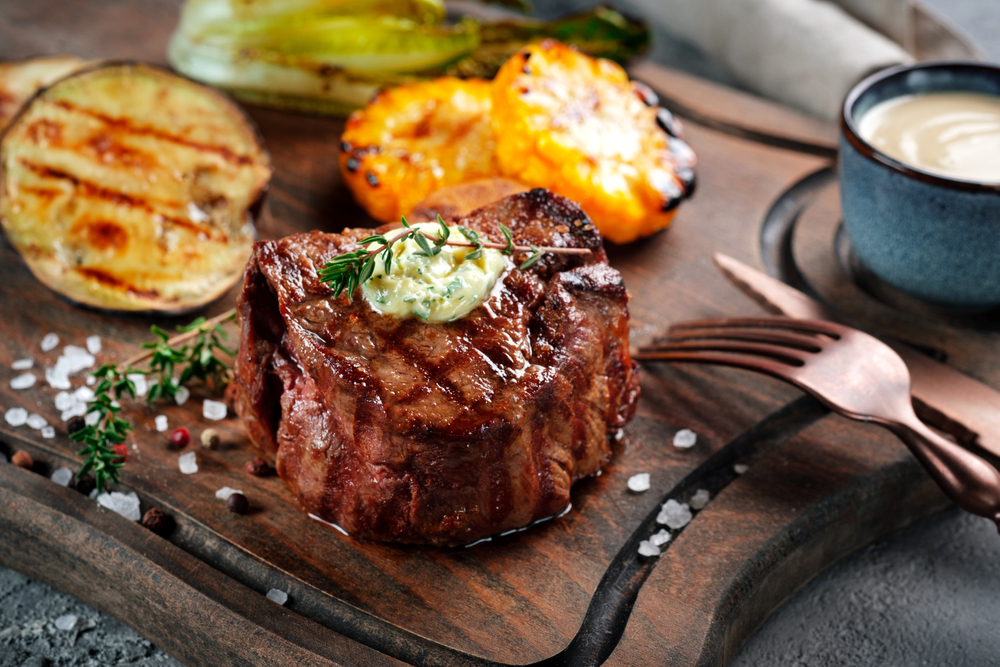 photo of a cooked filet mignon with herb butter topping 