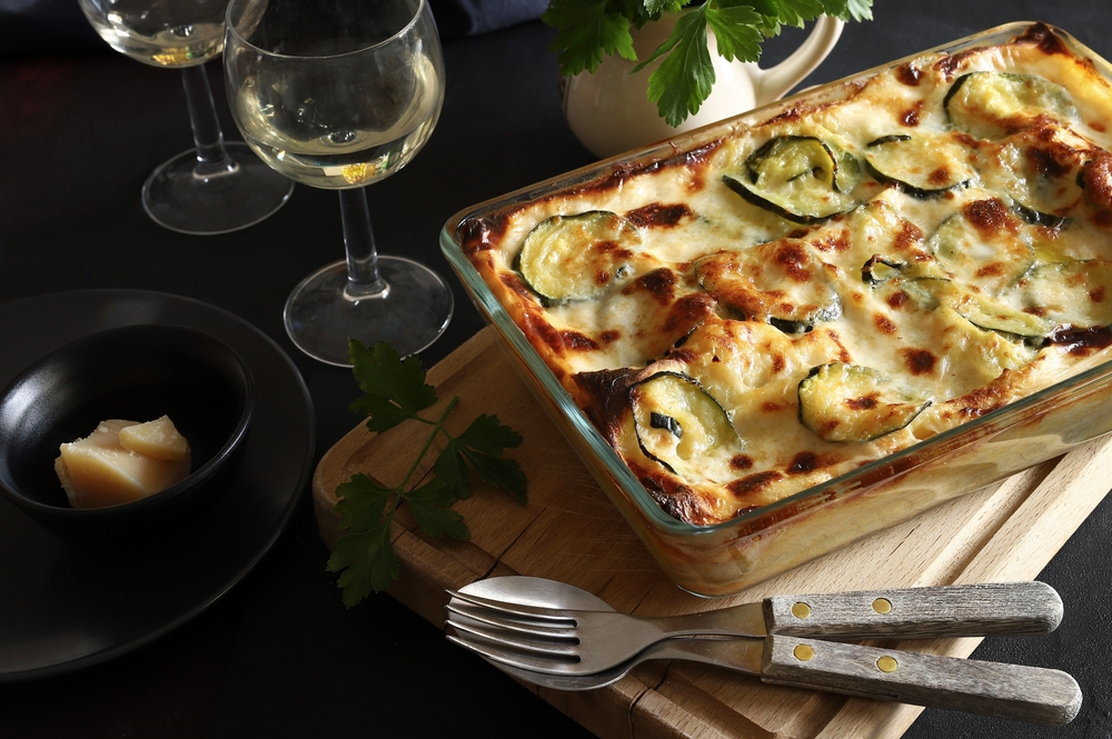 photo of vegetable lasagna with two glasses of wine that you can find at one of the best restaurants in Memphis 