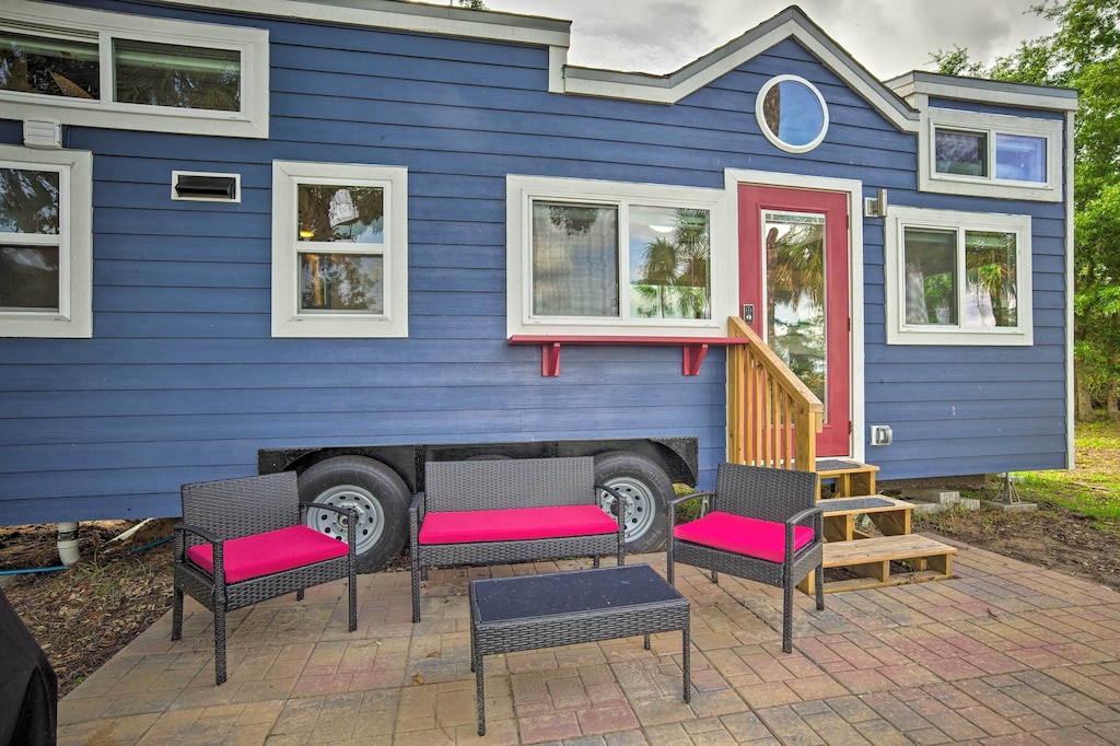 The lavender exterior, pink door and hot pink patio furniture of the Sweet Tiny House in South Carolina. 