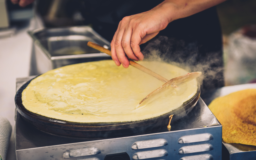 A man smooths out a crepe at one of the  best restaurants in San Antonio. 