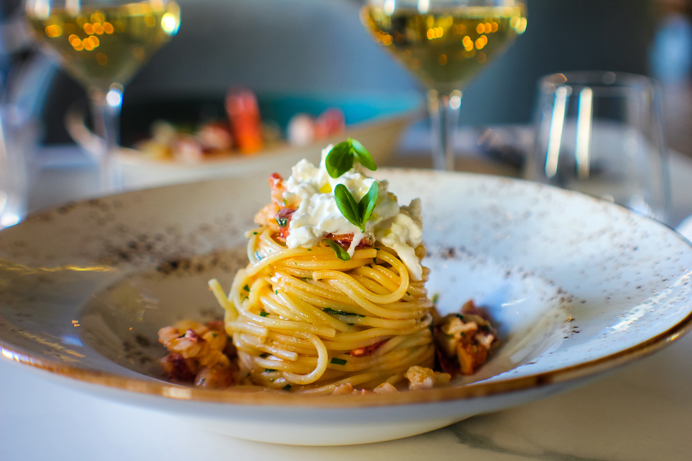 Pasta sits curled on a deep dish with creamy cheese on top at one of the best restaurants in San Antonio. 