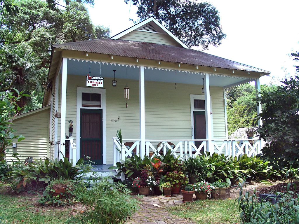cozy yellow cabin rentals in Louisiana with beautiful leafy gardens and flowers!